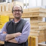 Man stands in front of lumber