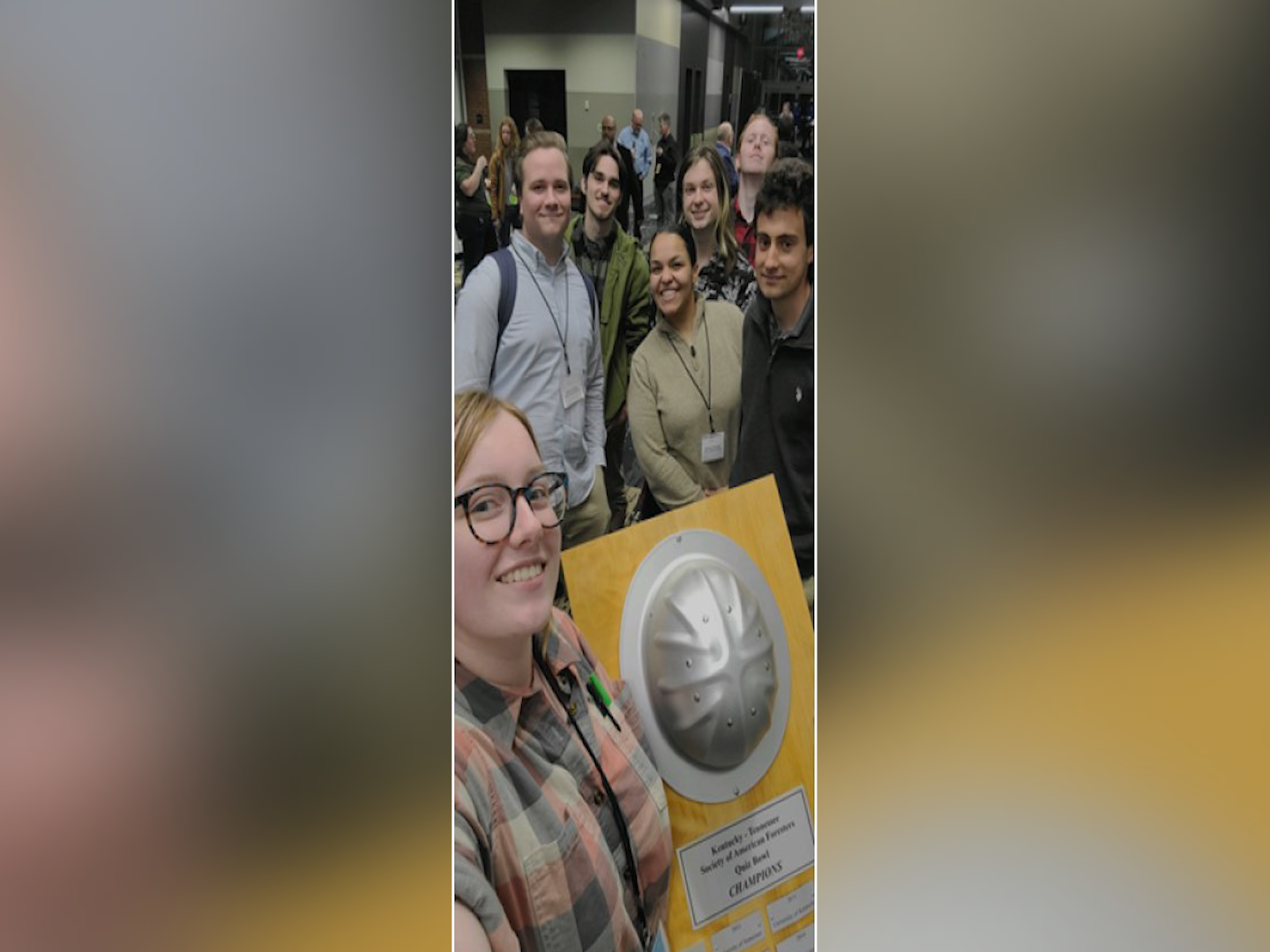 UT students hold trophy after winning quiz bowl.