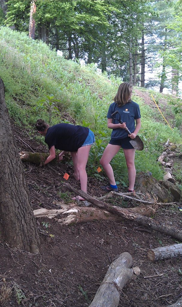 One student with shovel and one with log