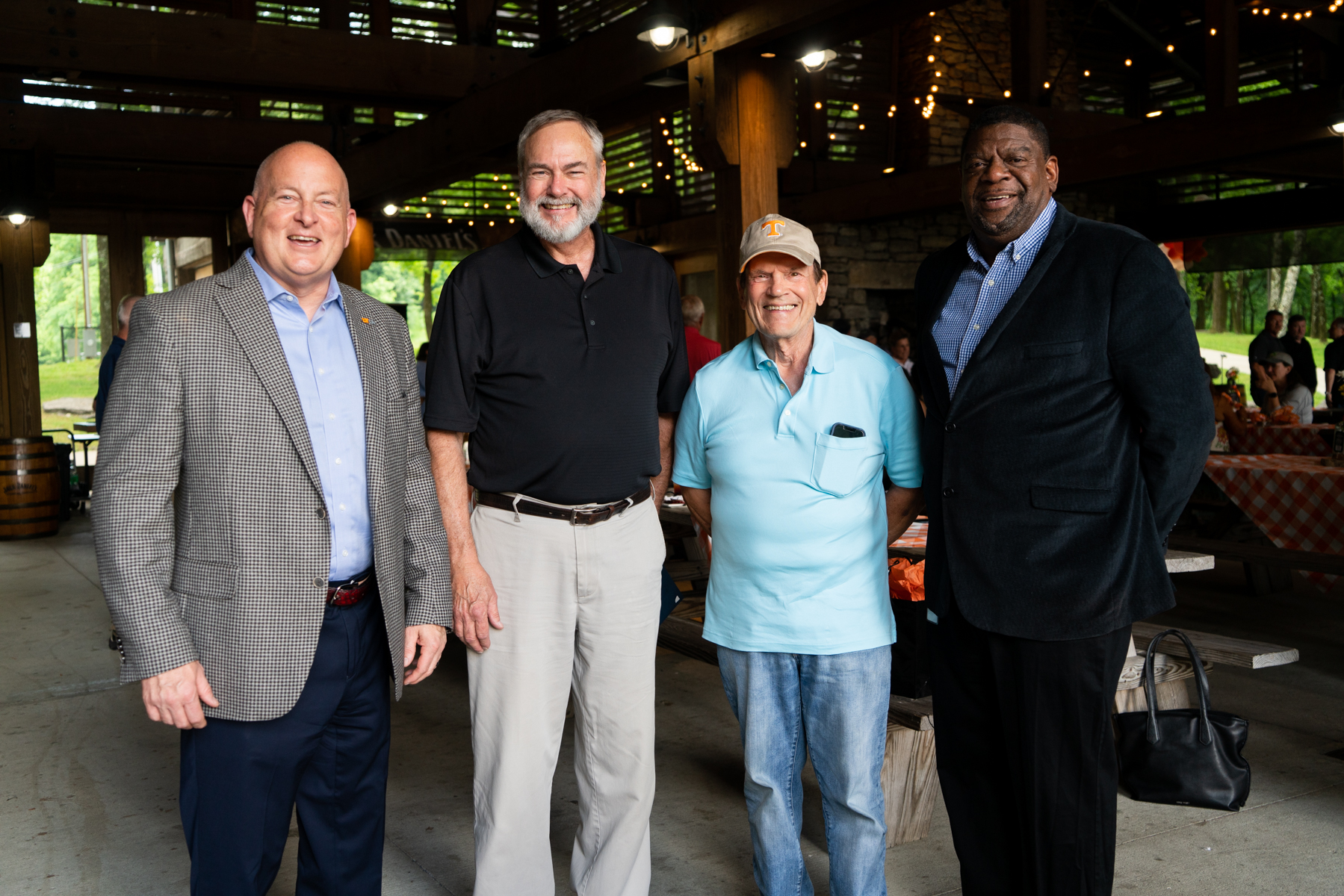 Four men standing in partial outdoor space.