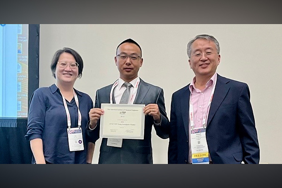 One person holds a certificate with two other people standing on both sides.