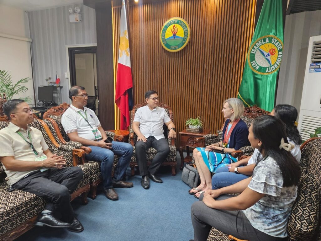 Six people sit in chairs in a room.