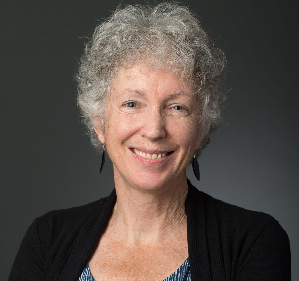 Woman in black sweater smiling.