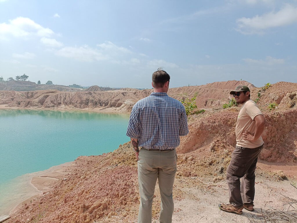 Two people stand next to a reclaimed mine.