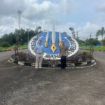 Two people stand in front of the University of Bangka Belitung sign.