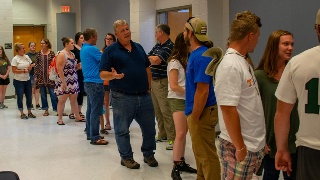 Several people stand in a line while talking.