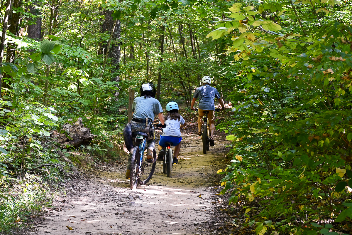 Three people bike on a trail.