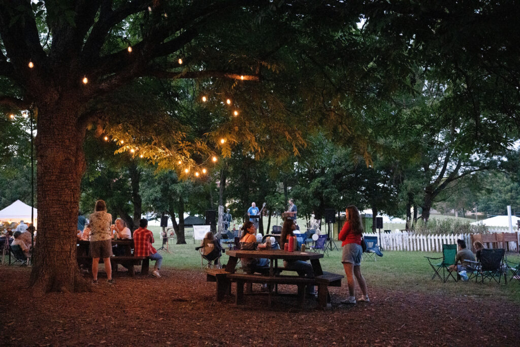 People sit or stand while listening to a band.