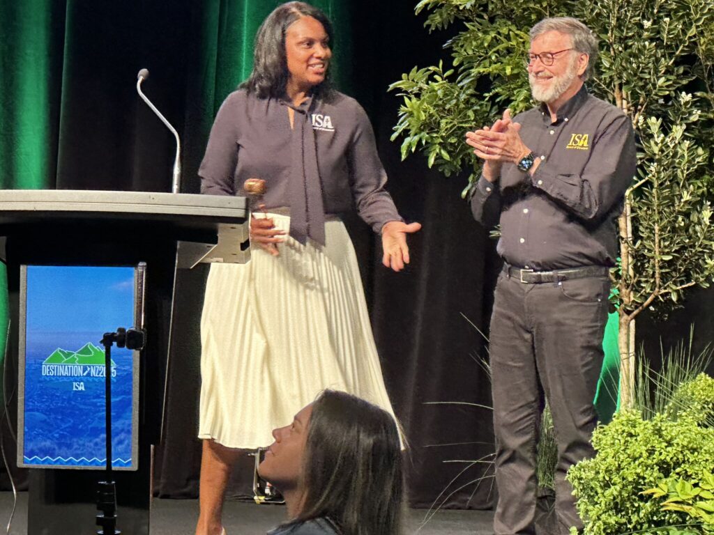 Two people stand next to a podium.