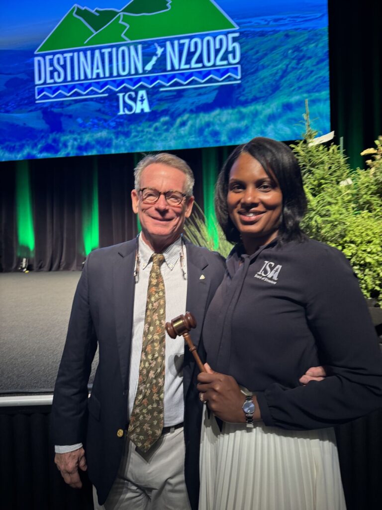 One person stands next to another person with a gavel.