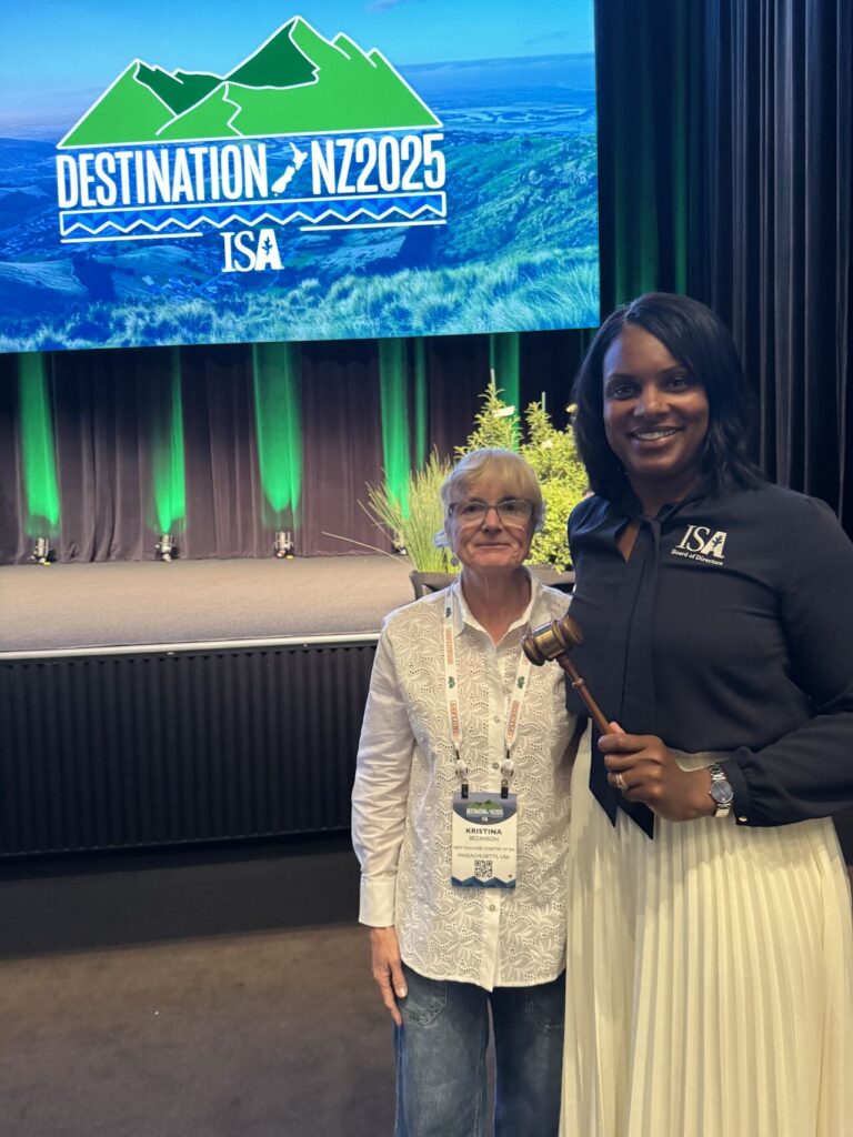 One person stands next to another person with a gavel.