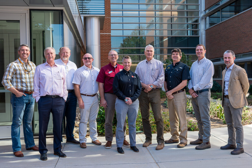 Ten people stand outside a building.