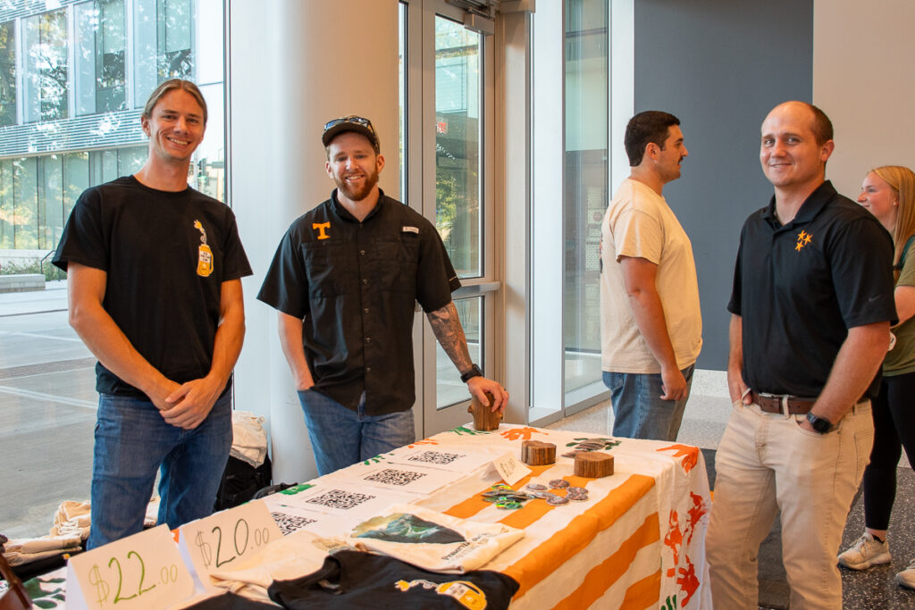 Four people pose around a table in a building on the UT Institute of Agriculture campus.