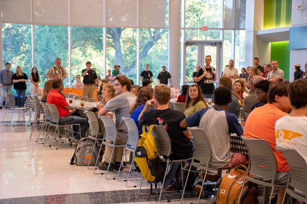 People sit at tables in a building on the UT Institute of Agriculture campus.