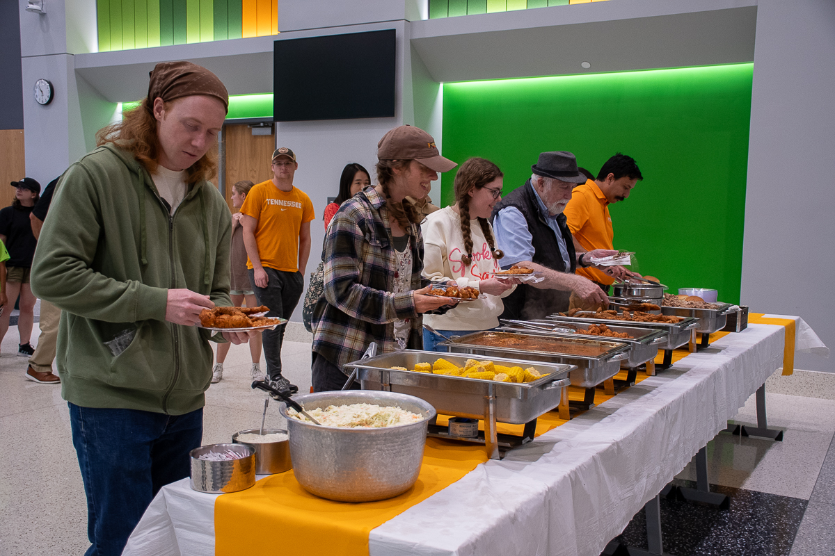 Seven people line up at a buffet table in a building on the UT Institute of Agriculture campus.