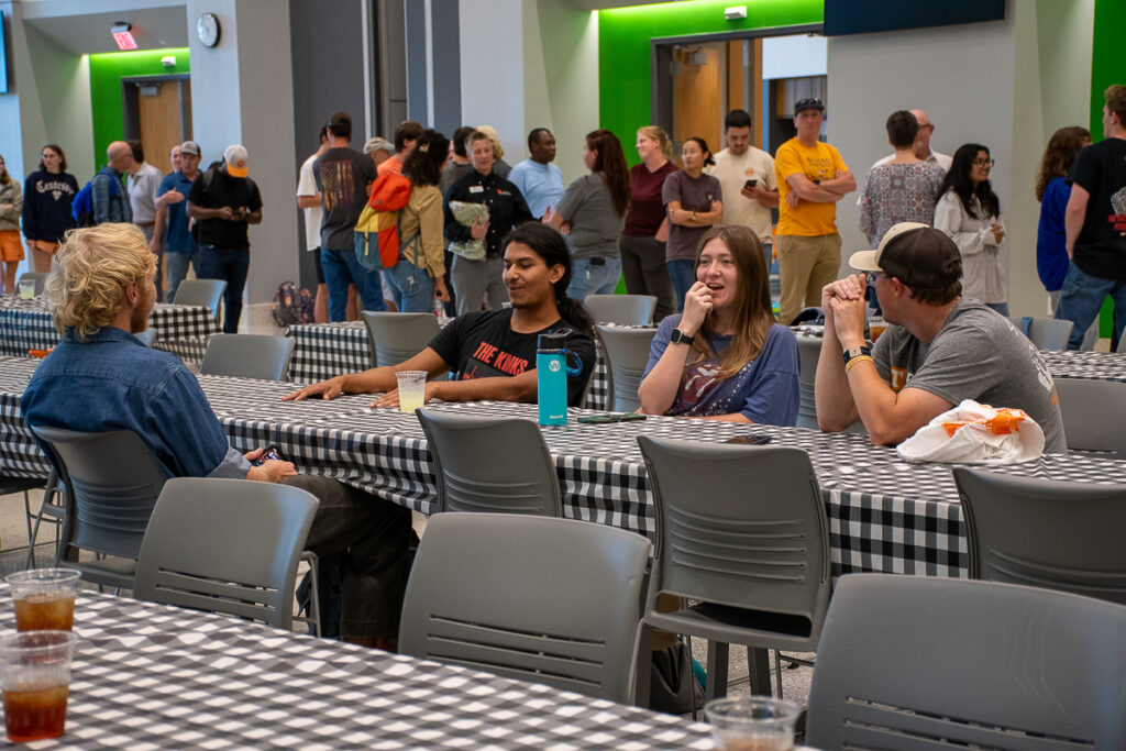 Four people sit at a table talking in a building on the UT Institute of Agriculture campus.
