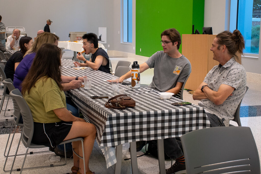 Six people sit and talk in a building on the UT Institute of Agriculture campus.