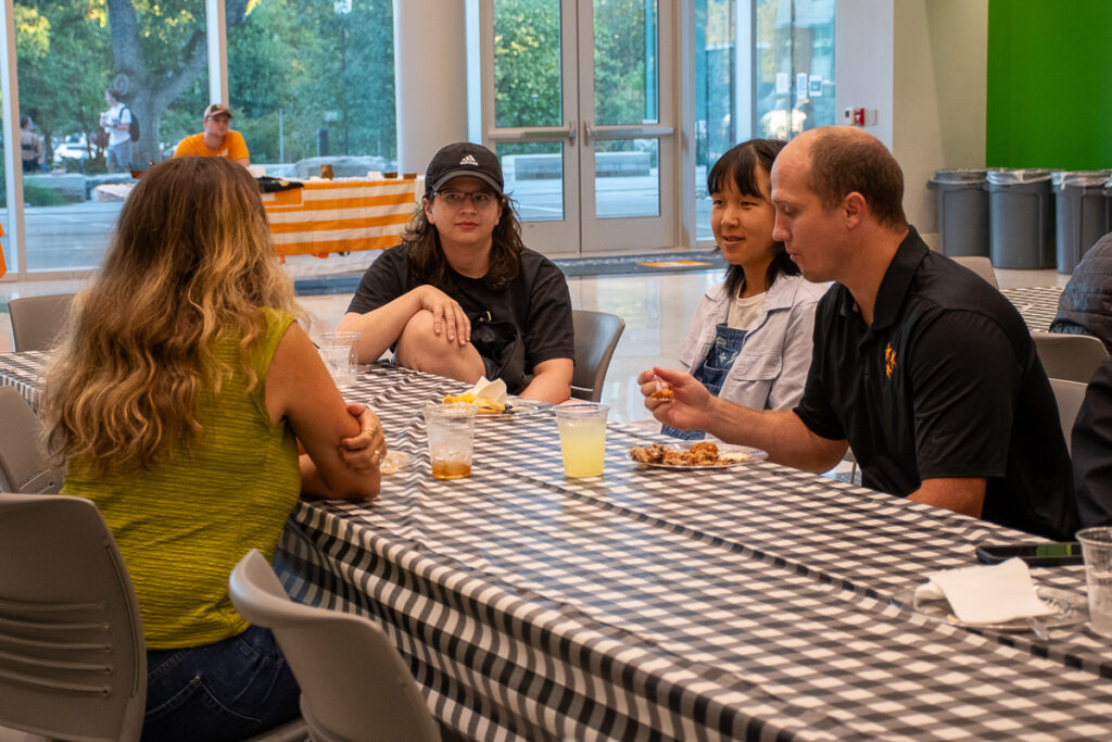 Four people sit and talk in a building on the UT Institute of Agriculture campus.