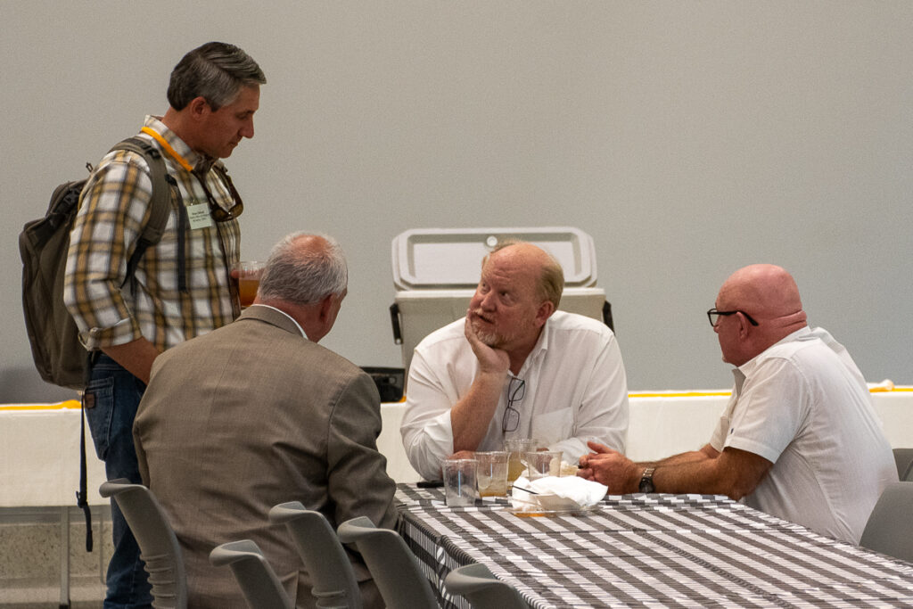 Four people sit and talk at a table in a building on the UT Institute of Agriculture campus.