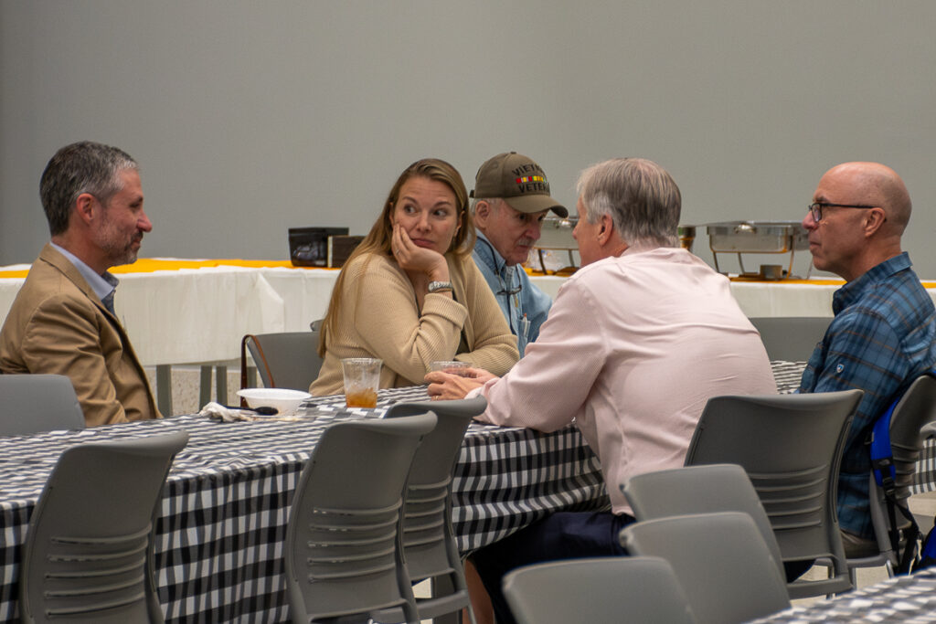 Five people sit and talk at a table in a building on the UT Institute of Agriculture campus.