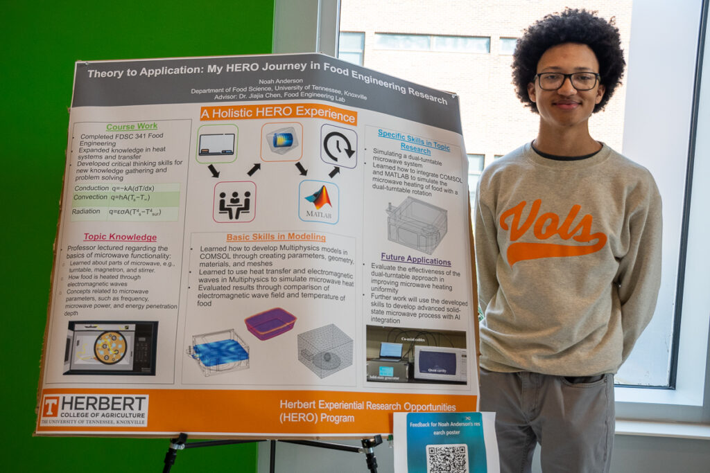 A person stands next to a poster in the Agriculture and Natural Resources Building at the UT Institute of Agriculture.