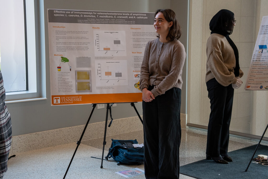 Two people stand near a poster in the Agriculture and Natural Resources Building at the UT Institute of Agriculture.