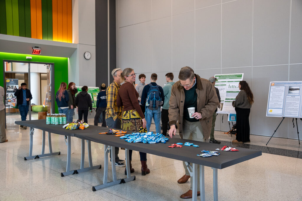 Several people stand around a table with snacks on it in the Agriculture and Natural Resources Building at the UT Institute of Agriculture.