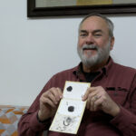 Professor Scott Schlarbaum holds a paper plate showing three chromosomes.