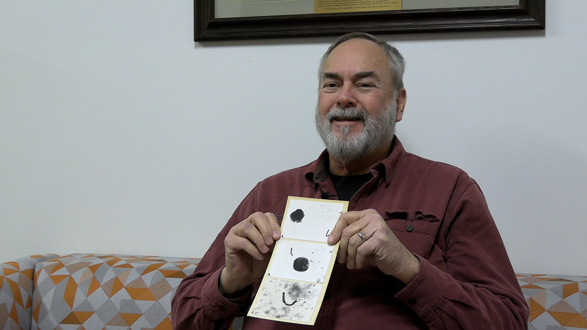 Professor Scott Schlarbaum holds a paper plate showing three chromosomes.