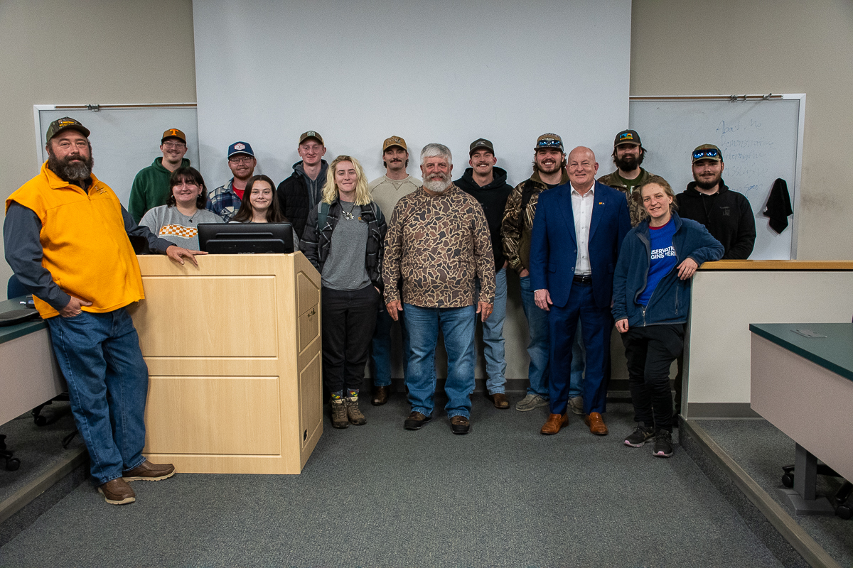 Fifteen people stand in a room by a podium on the UT Institute of Agriculture campus.