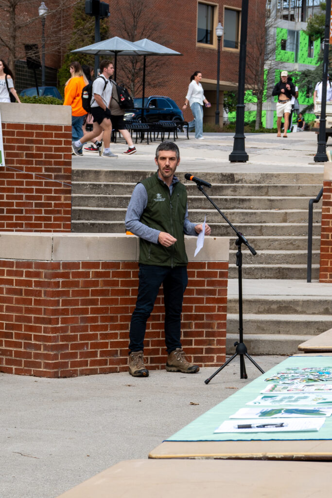 A man gives a speech in a microphone on the University of Tennessee campus.