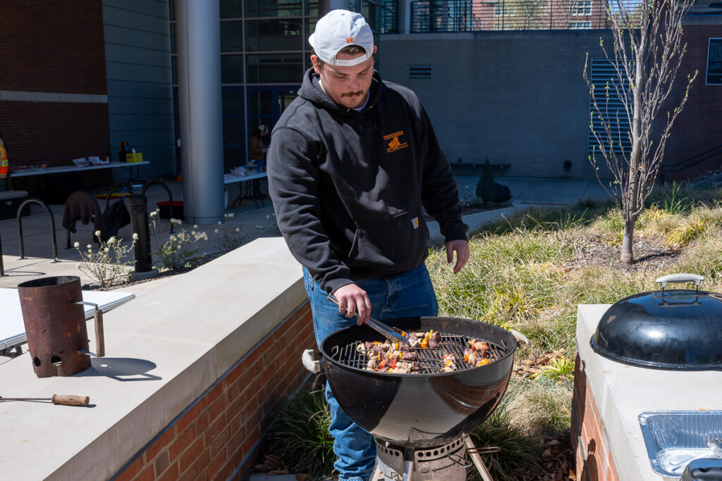A person grills outside a building on the UT Institute of Agriculture campus.
