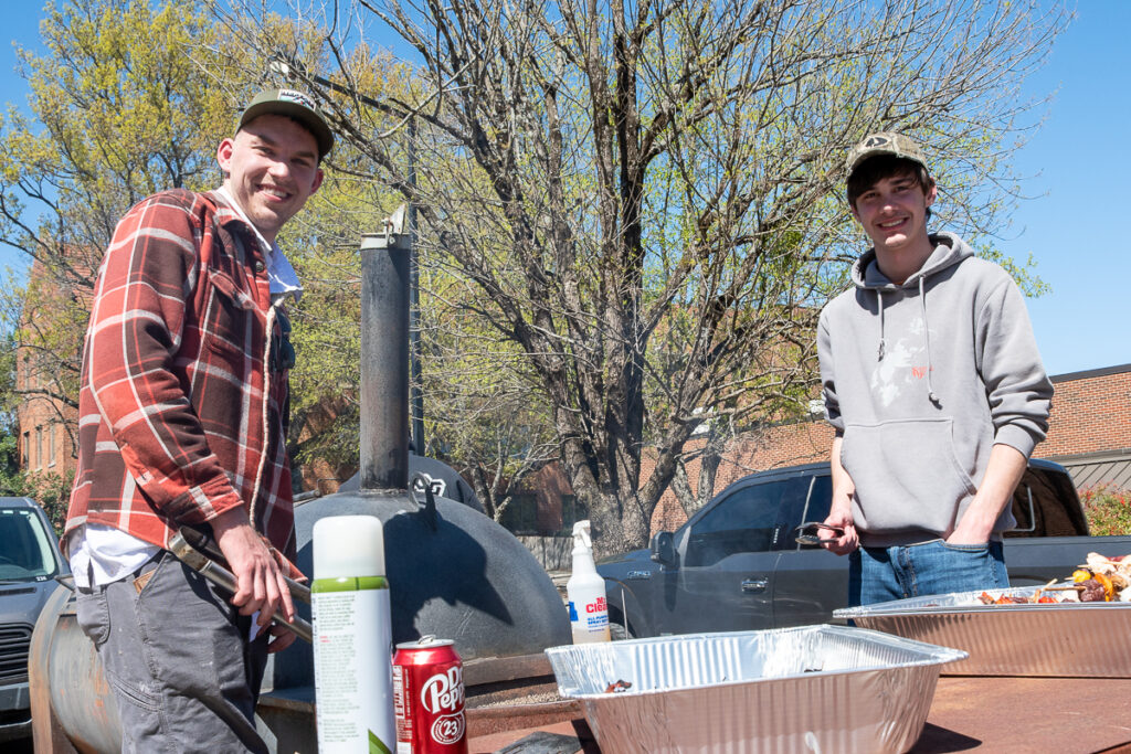 Two people stand by a smoker outside a building on the UT Institute of Agriculture campus.