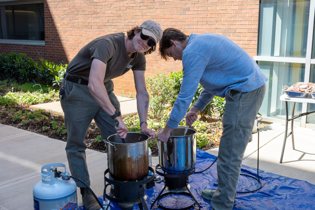 Two people use fryers outside a building on the UT Institute of Agriculture campus.