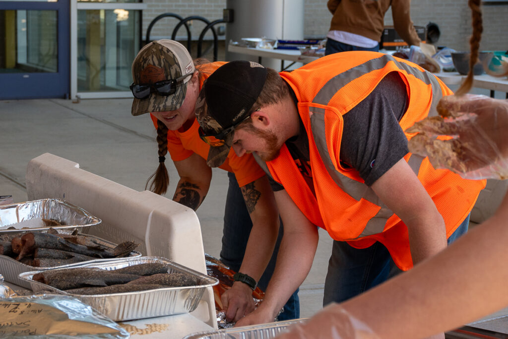Two people look into a cooler outside a building on the UT Institute of Agriculture campus.