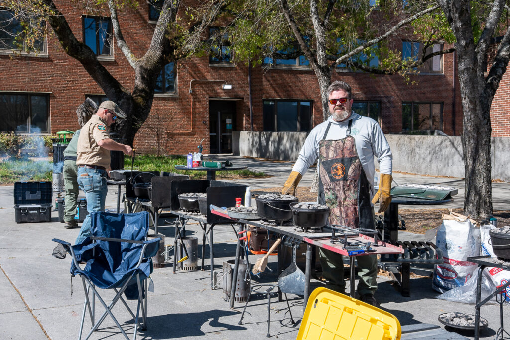 Two people stand beside grills outside a building on the UT Institute of Agriculture campus.