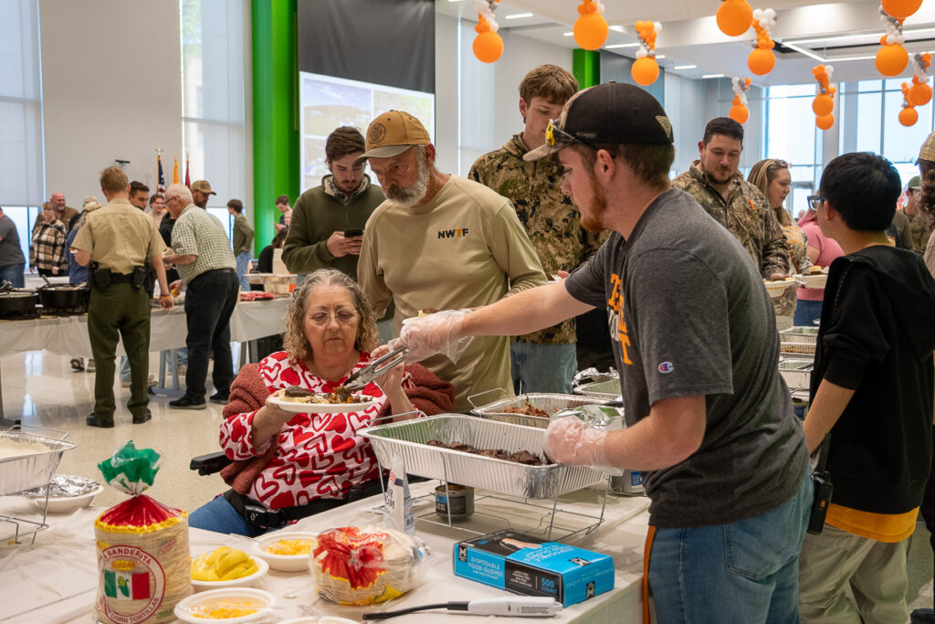 A person serves another in a buffet line in a building on the UT Institute of Agriculture campus.