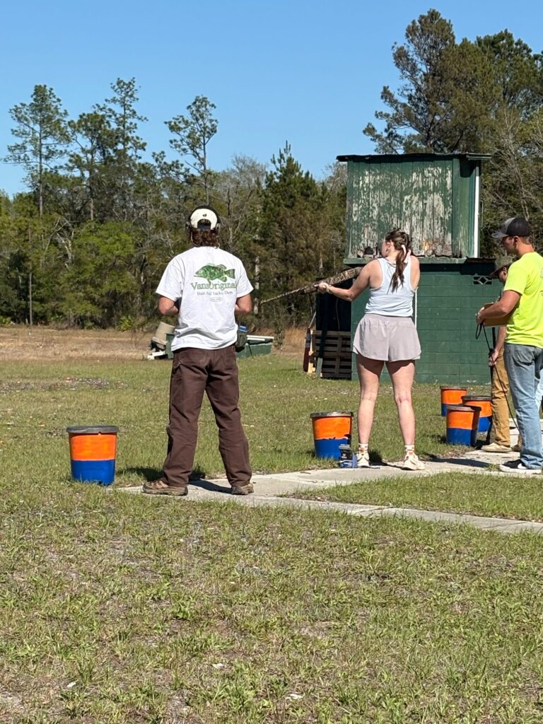 Three people compete in a shooting competition at the University of Florida.