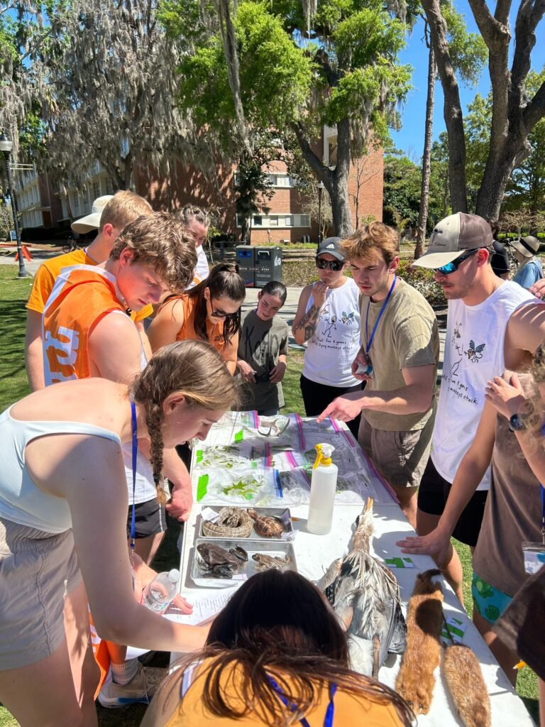 Eleven people stand around a table outside at the University of Florida.