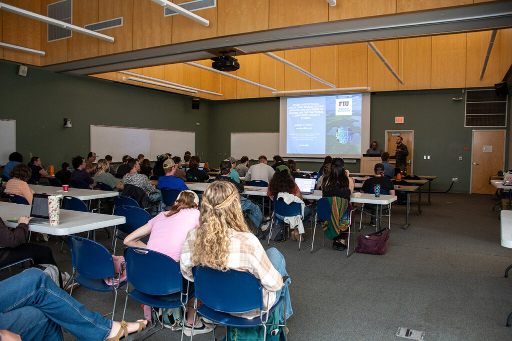 People sit and stand in a room on the UT Institute of Agriculture.