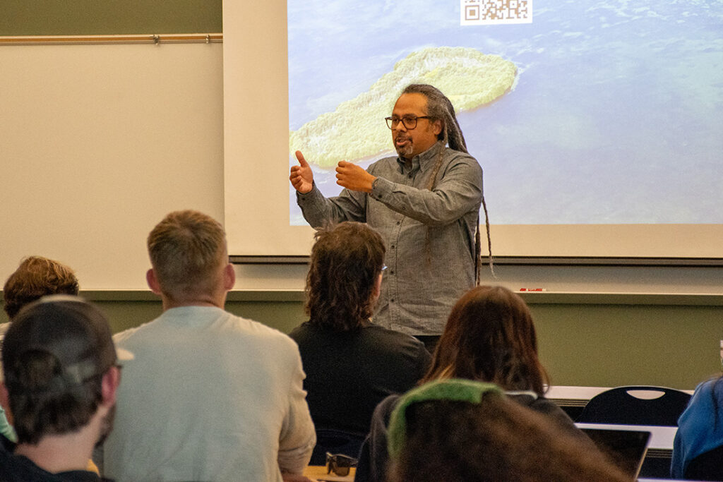 A person speaks to people sitting down in a room on the UT Institute of Agriculture.