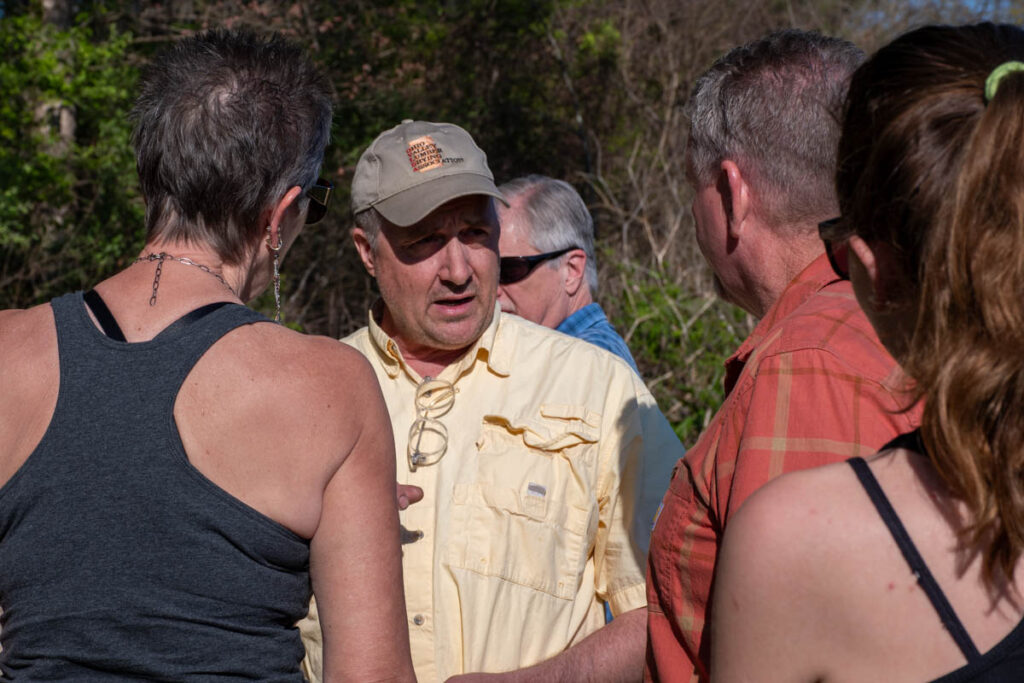 Five people stand and talk at the UT Arboretum.