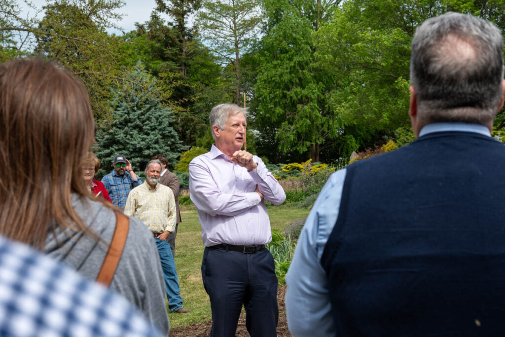 A person speaks to a crowd of people in UT Gardens.
