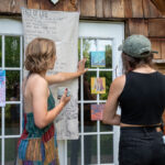 Two people look at artwork on a door.
