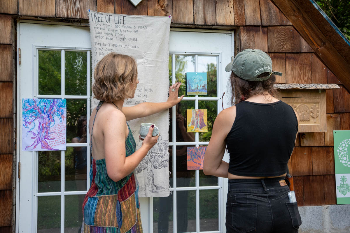 Two people look at artwork on a door.