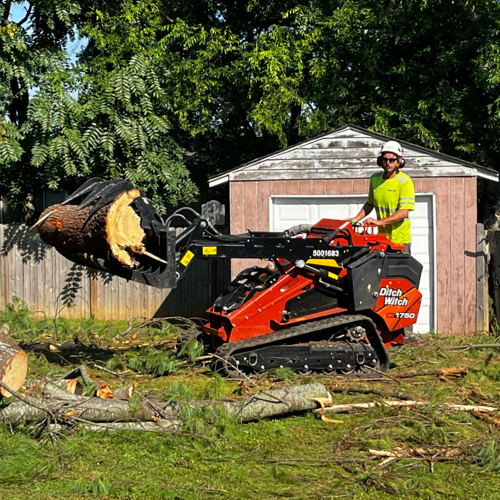 Person wearing helmet and protective eyewear while operating heavy machinery.