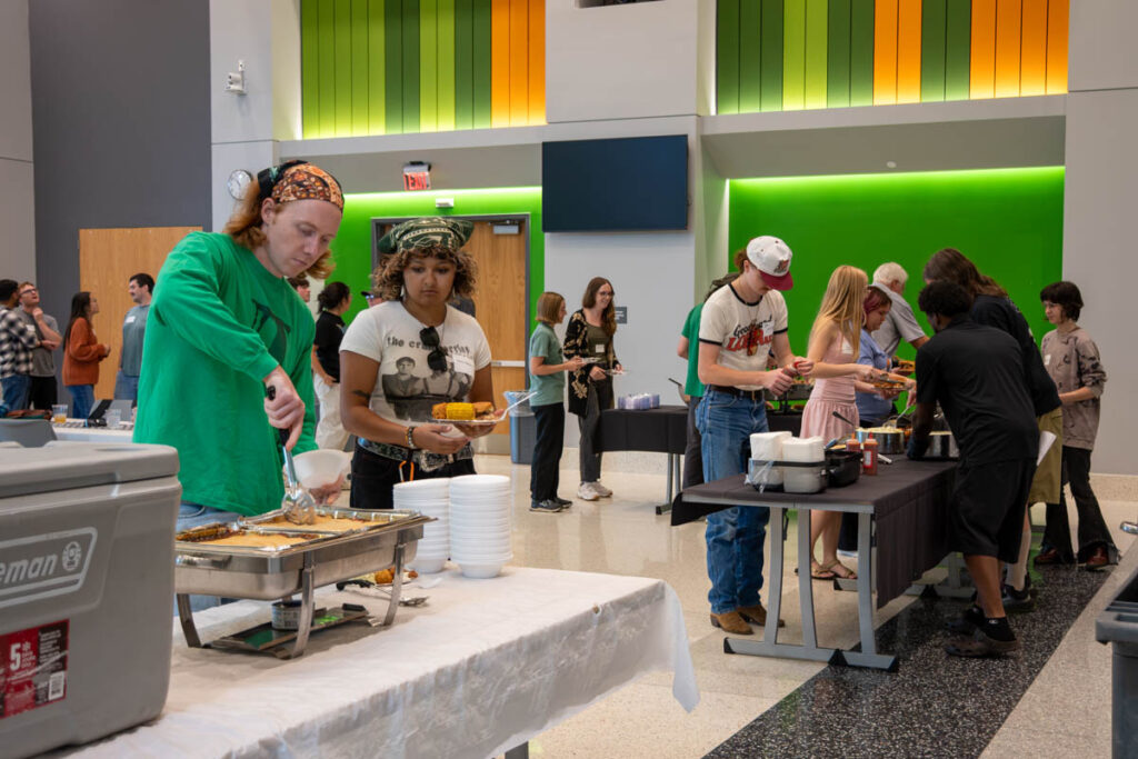 Eight people put food on their plates in a buffet line in a building on the UT Institute of Agriculture campus.