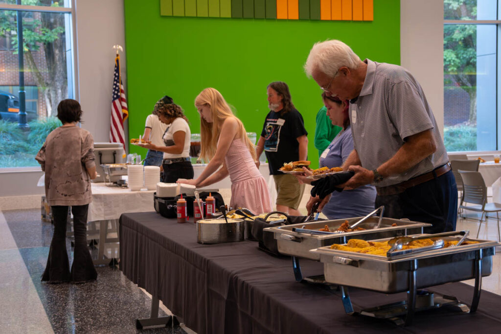 Six people line up in a buffet line in a building on the UT Institute of Agriculture campus.