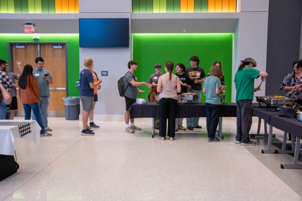 More than a dozen people line up behind a buffet table in a building on the UT Institute of Agriculture campus.