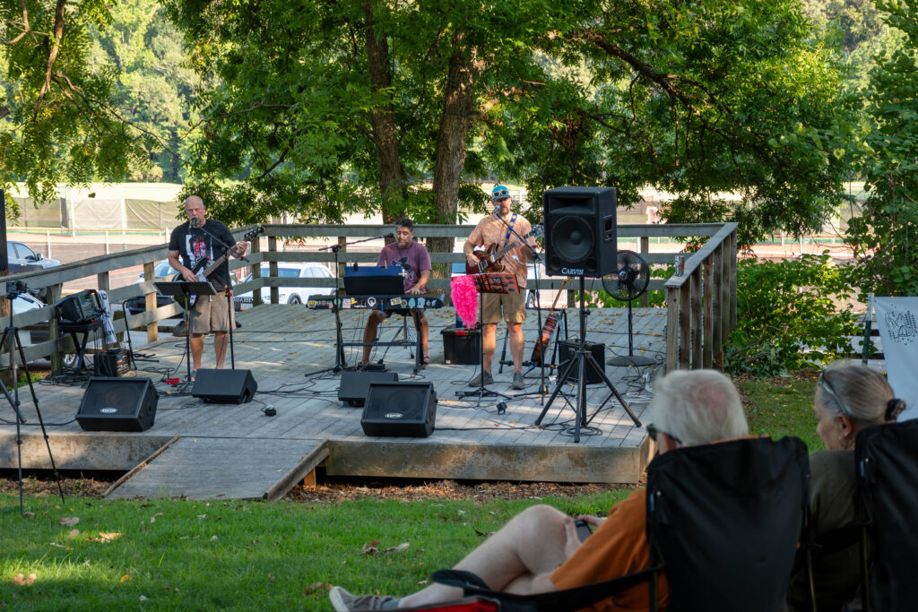 A three-member band plays on an outdoor stage on Maryville College campus.